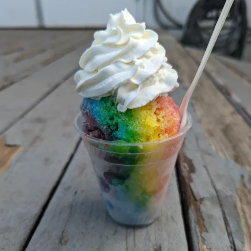 Rainbow snowball topped with whipped cream, a colorful option for wedding catering