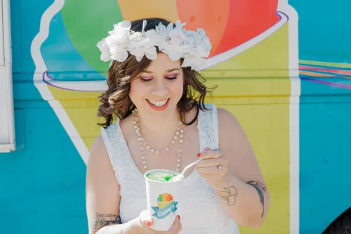 A smiling bride enjoying a Casey's snowball on her wedding day